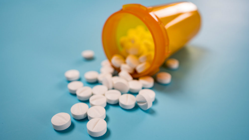 Pills spilling out of a prescription pot