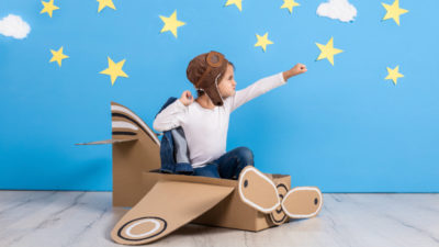 little girl in pilot costume playing and dreaming of flying over the sky