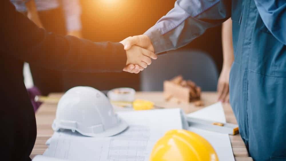 Businessman and engineer handshake closing a deal in construction site