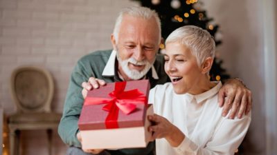 Elderly man giving a Christmas present to his wife