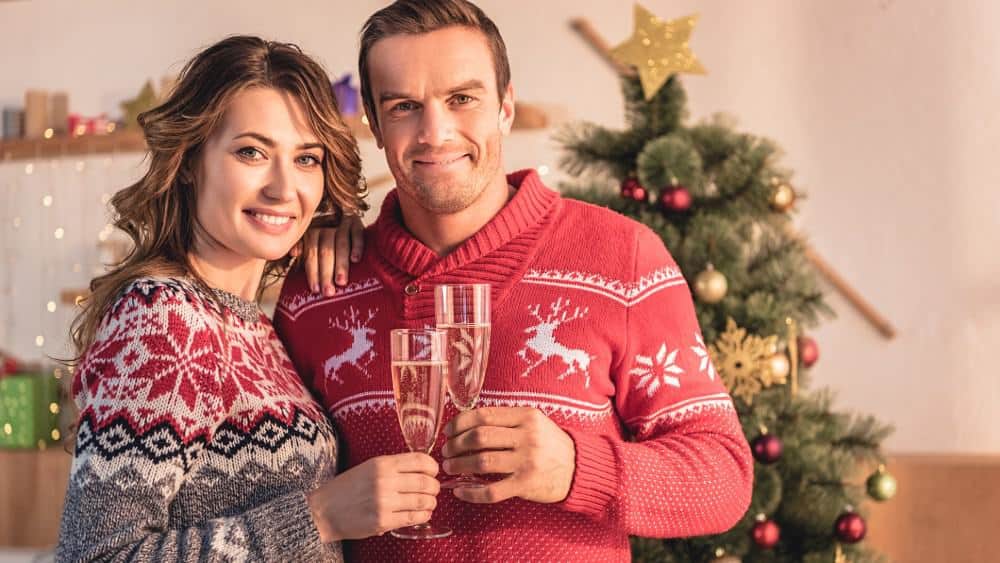 smiling couple at home with christmas tree