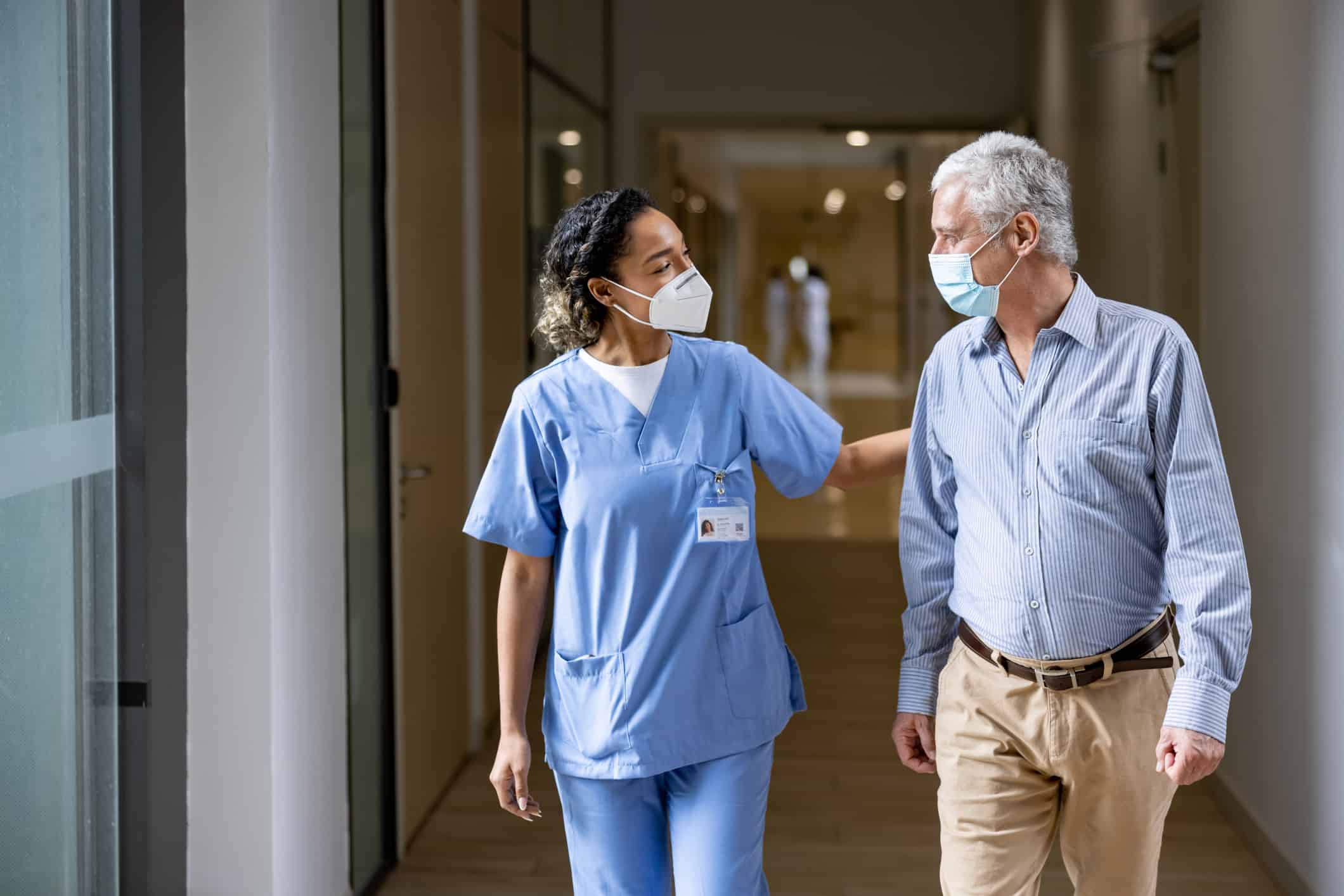 Doctor talking to a patient in the corridor of a hospital.