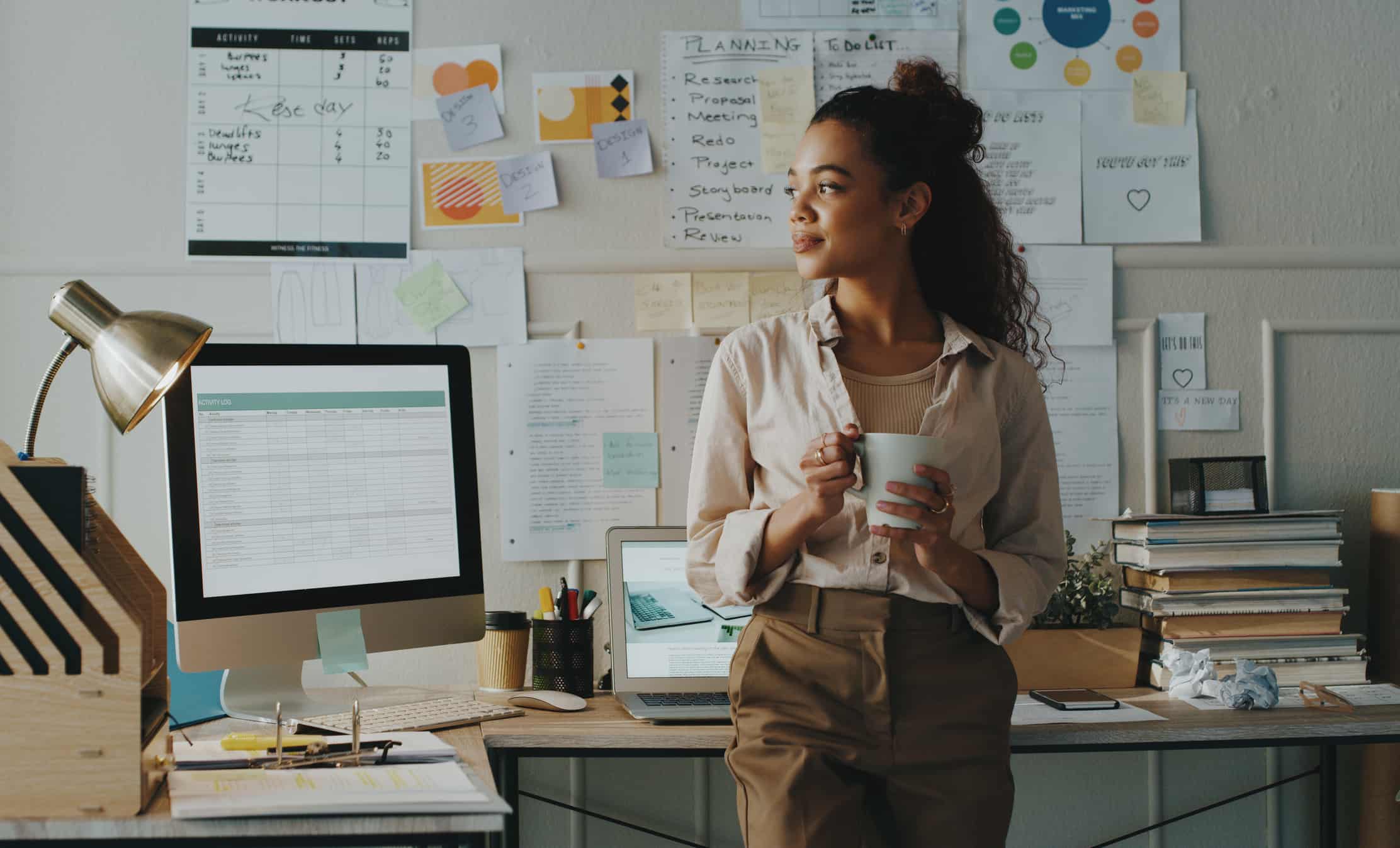 A worker drinks out of a mug in an office.