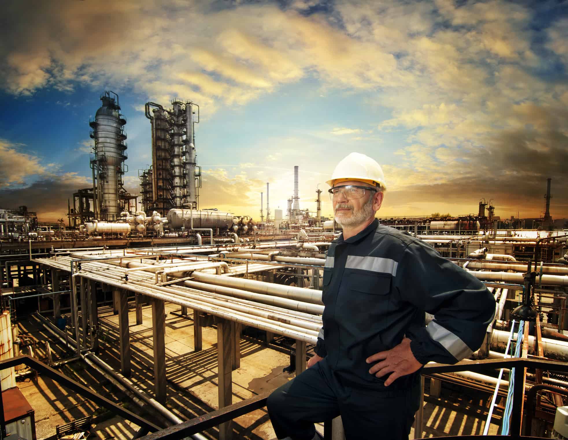 A worker overlooks an oil refinery plant.