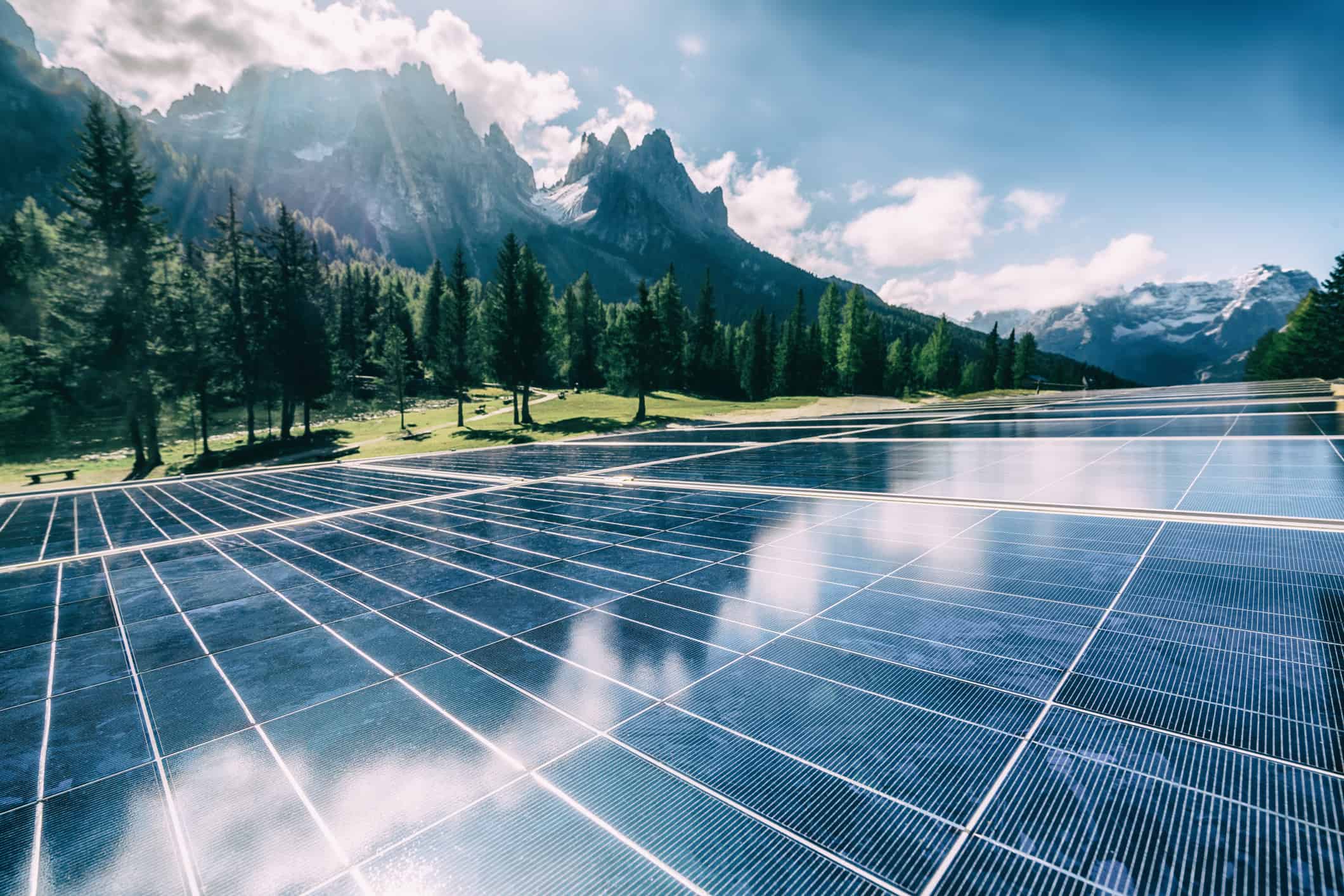 A solar cell panel generates power in a country mountain landscape.