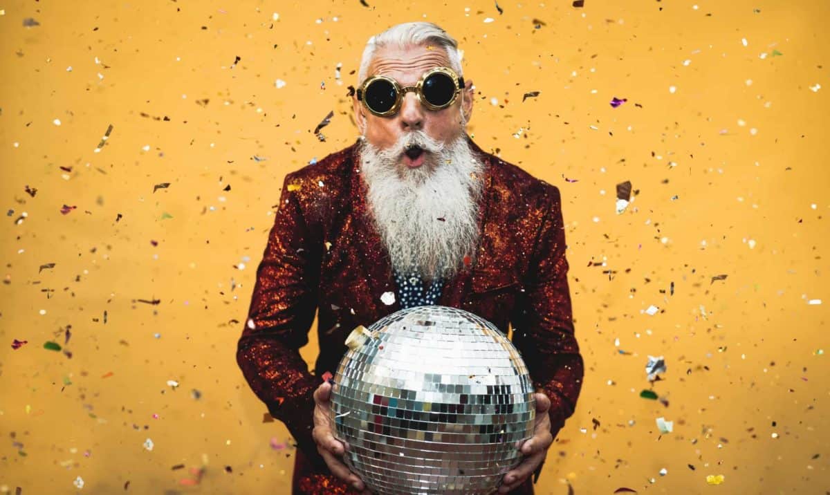 a man celebrates his good fortune with a disco ball and confetti