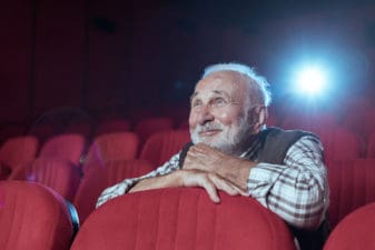 man is enthralled with a movie in a theater