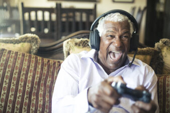 A man smiles while playing a video game.