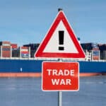 Warning sign with the text "Trade war" in front of container ship