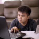 Young adult concentrates on laptop screen