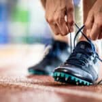 athlete ties shoes before starting to exercise