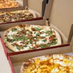 various pizza in boxes in a row for lunch