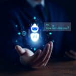 A person's hand cupped open with a hologram of an AI chatbot above saying Hi, can I help you