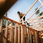 builder frames a house with lumber