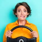 woman holding steering wheel is nervous about the future