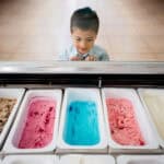 child looks at variety of flavors at ice cream store