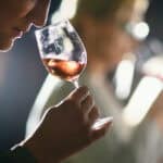 drinker sniffs wine in a glass
