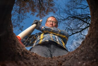 man with shovel stands by a hole